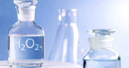Glazen flesje met waterstofperoxide voor spoelen op een schone, witte ondergrond