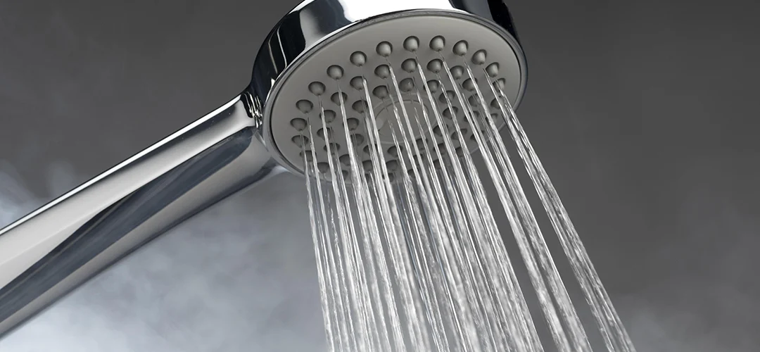 Foto van een douchekop met stoom op de achtergrond